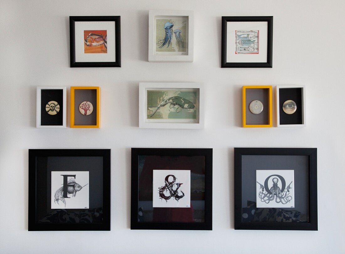 Framed initials in black frames below small pictures of animals and badges on wall