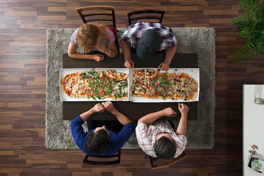 Four people eating pizza