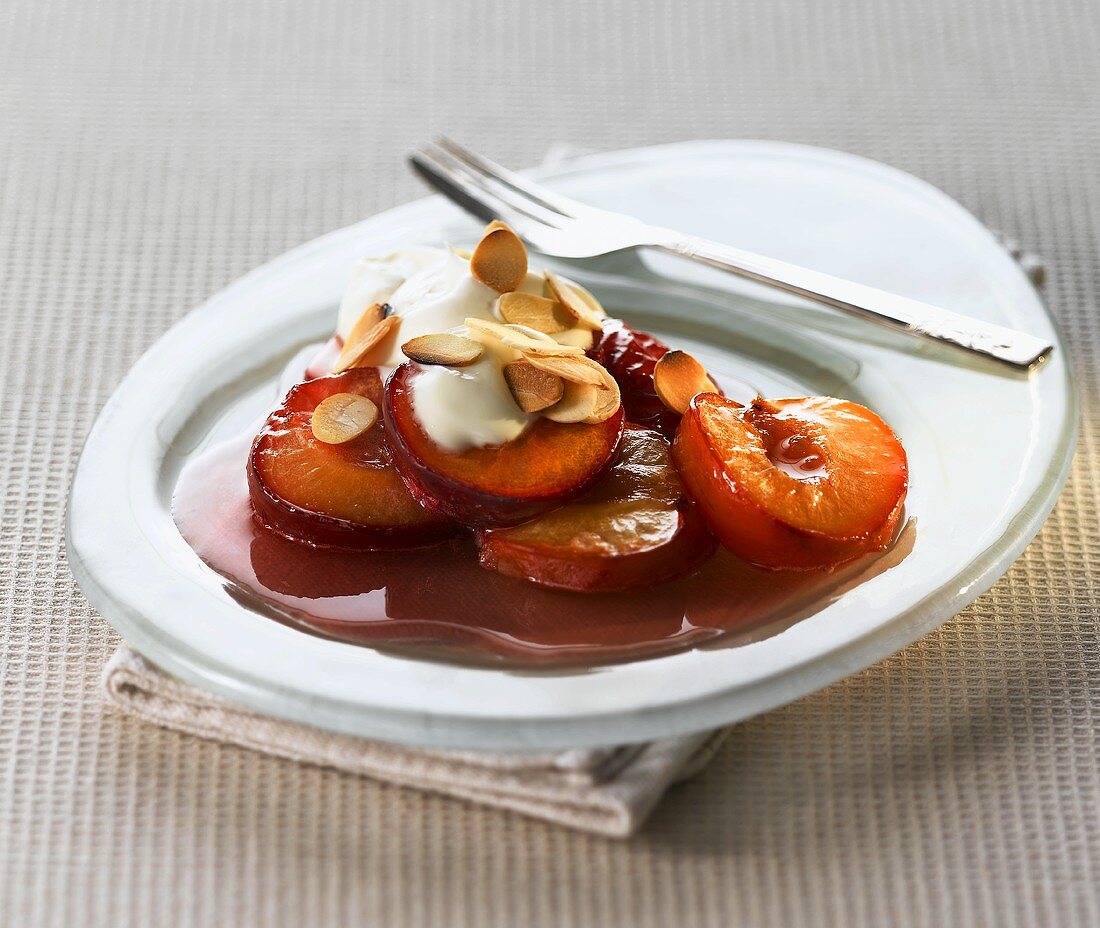 Plums in syrup with cream and slivered almonds
