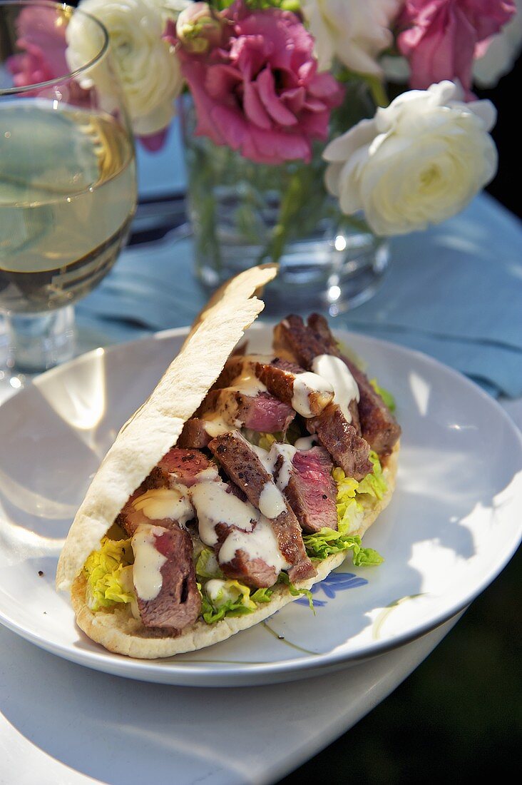 A Caesar salad and beef steak sandwich