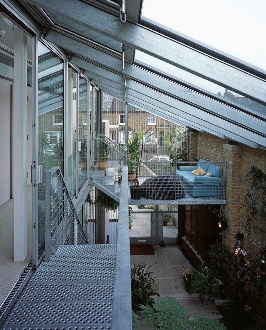 Covered courtyard with glass roof and with the stair access made of metal and gratings