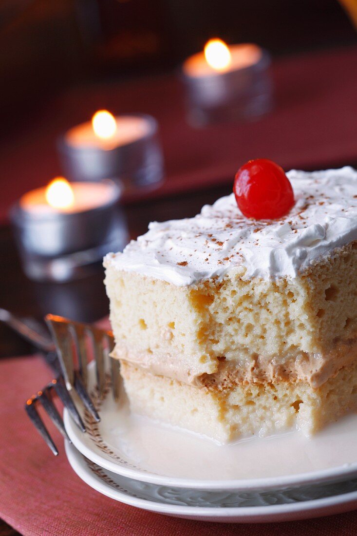 Tres Leches Cake with Cinnamon and a Cherry; Partially Eaten