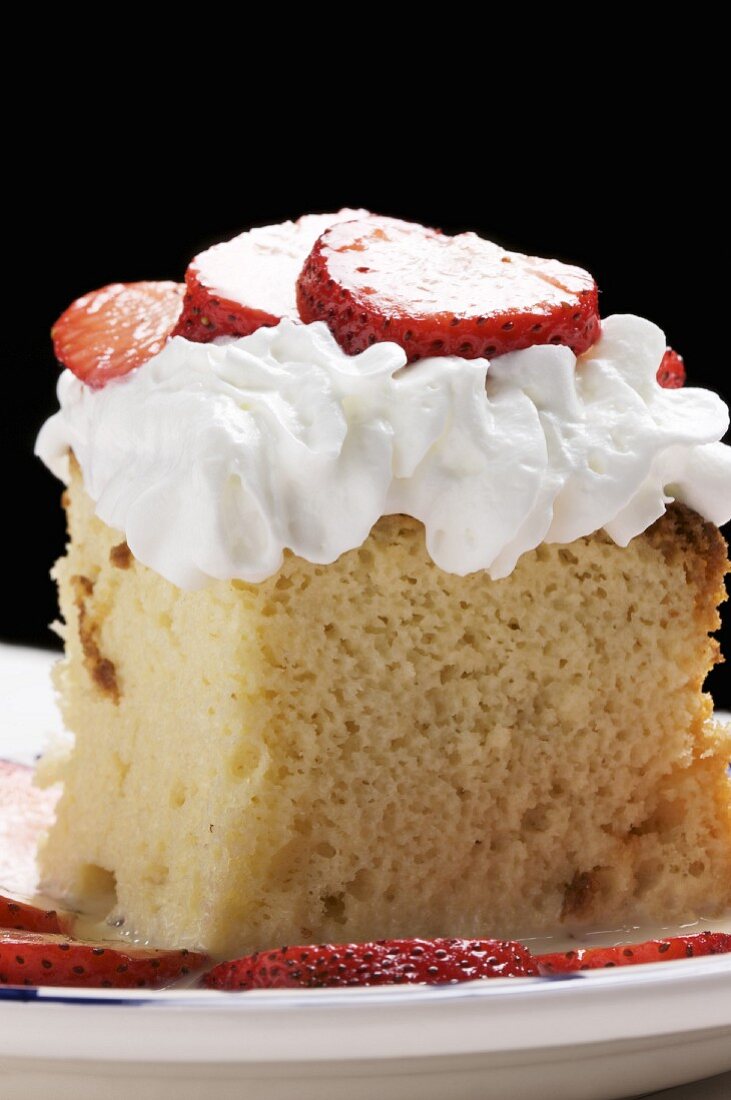 Piece of Tres Leches Cake with Whipped Cream and Strawberries