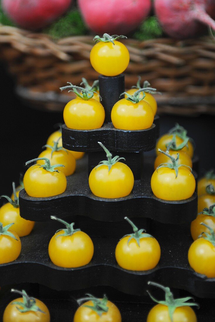 A pyramid of yellow tomatoes on a market stand