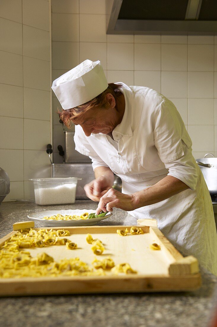 A woman making tortellini