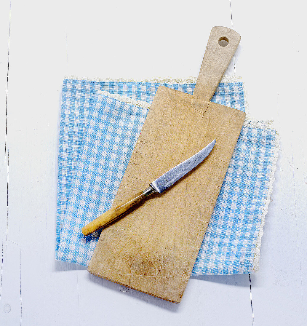 A knife and a chopping board on a cloth