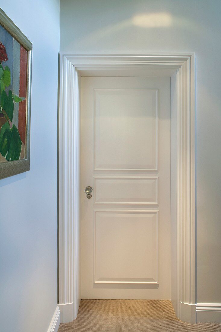 Hallway with white door and profiled (door) trim