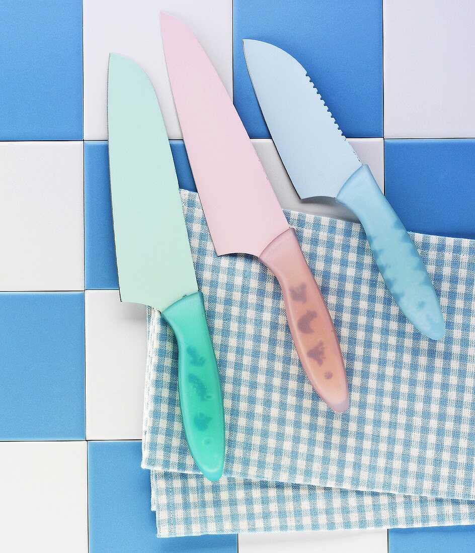 Various knives on a tea towel