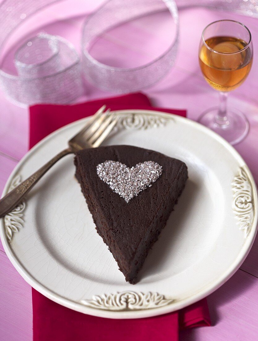 Ein Stück Schokoladenkuchen mit Herz aus Silberzucker