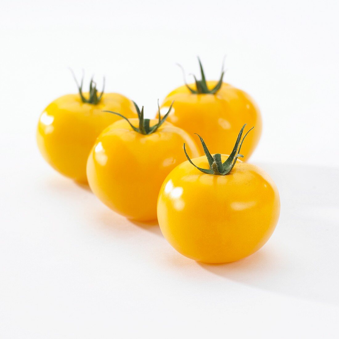 Vier gelbe Tomaten (Lycopersicon)
