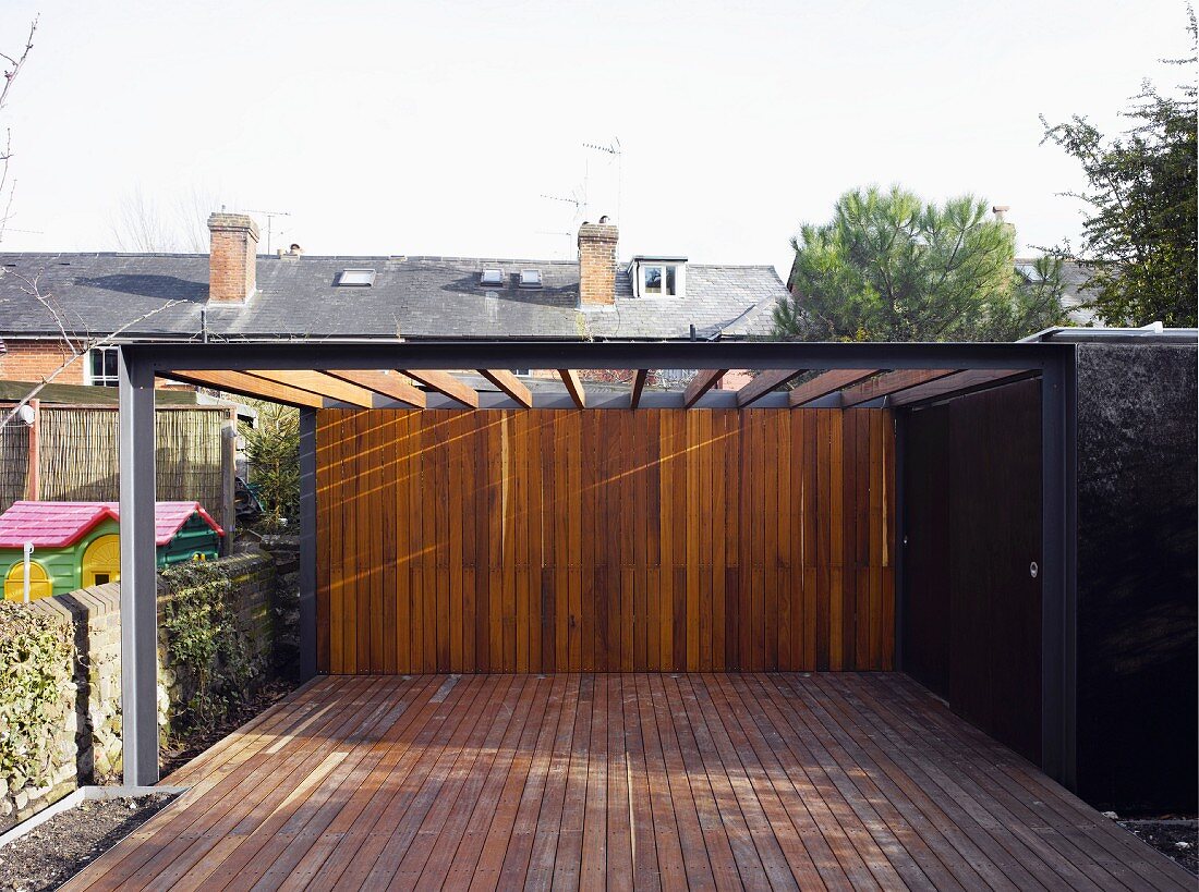 Pergola über zeitgenössischer Terrasse aus Holz in Wand übergehend