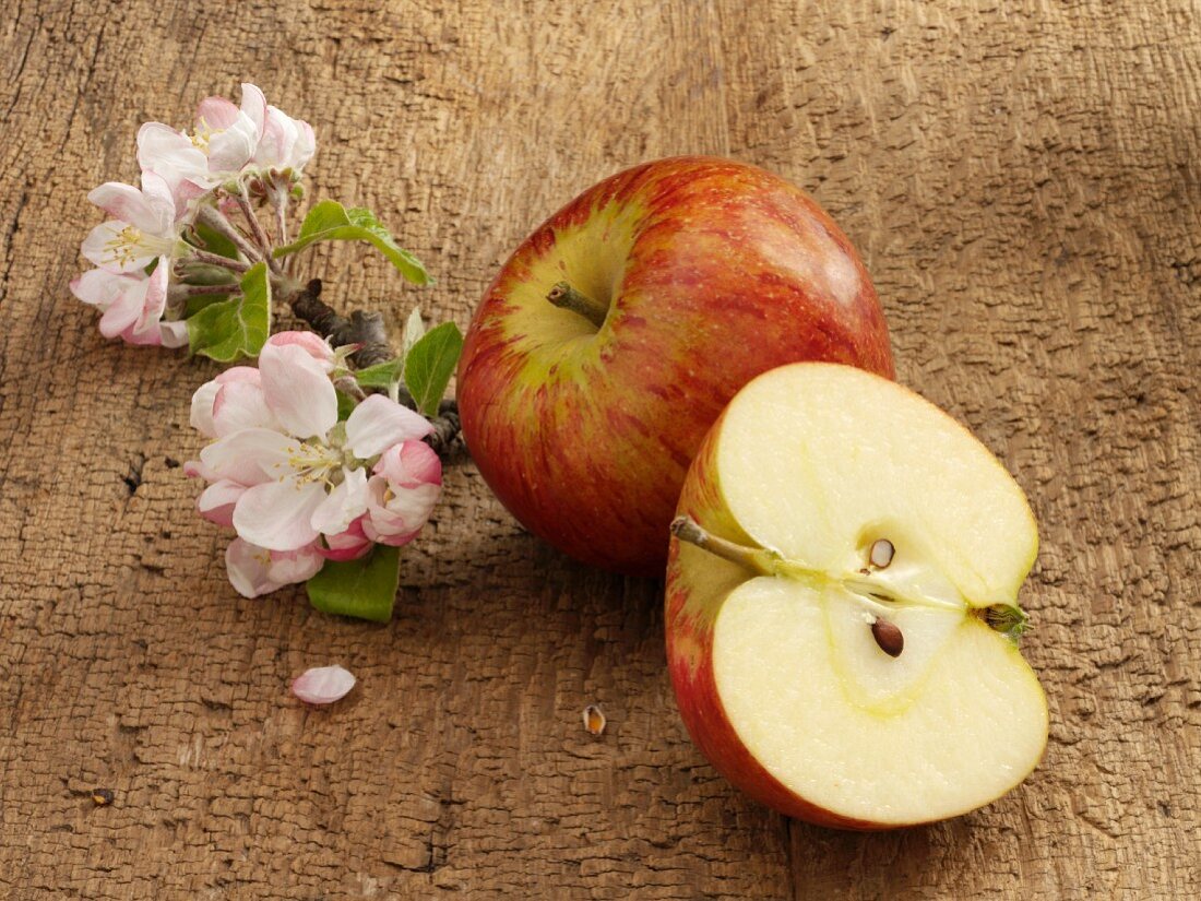 Apfel, Apfelblüten und halbierter Apfel