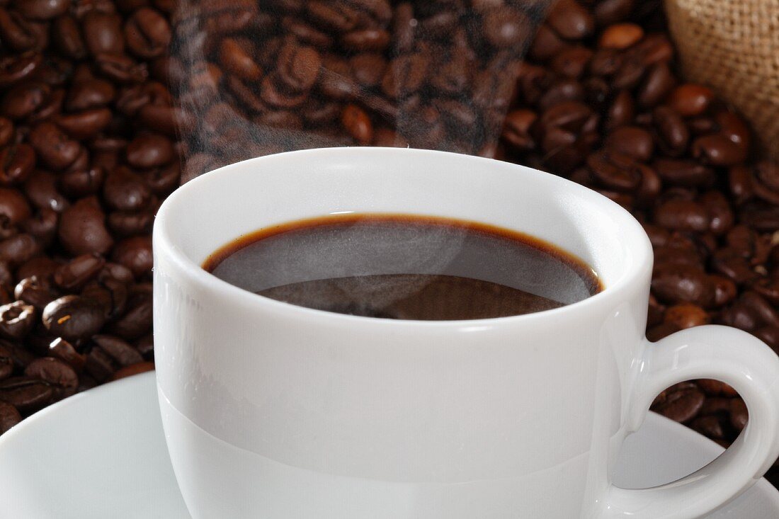 Kaffeetasse vor Kaffebohnen