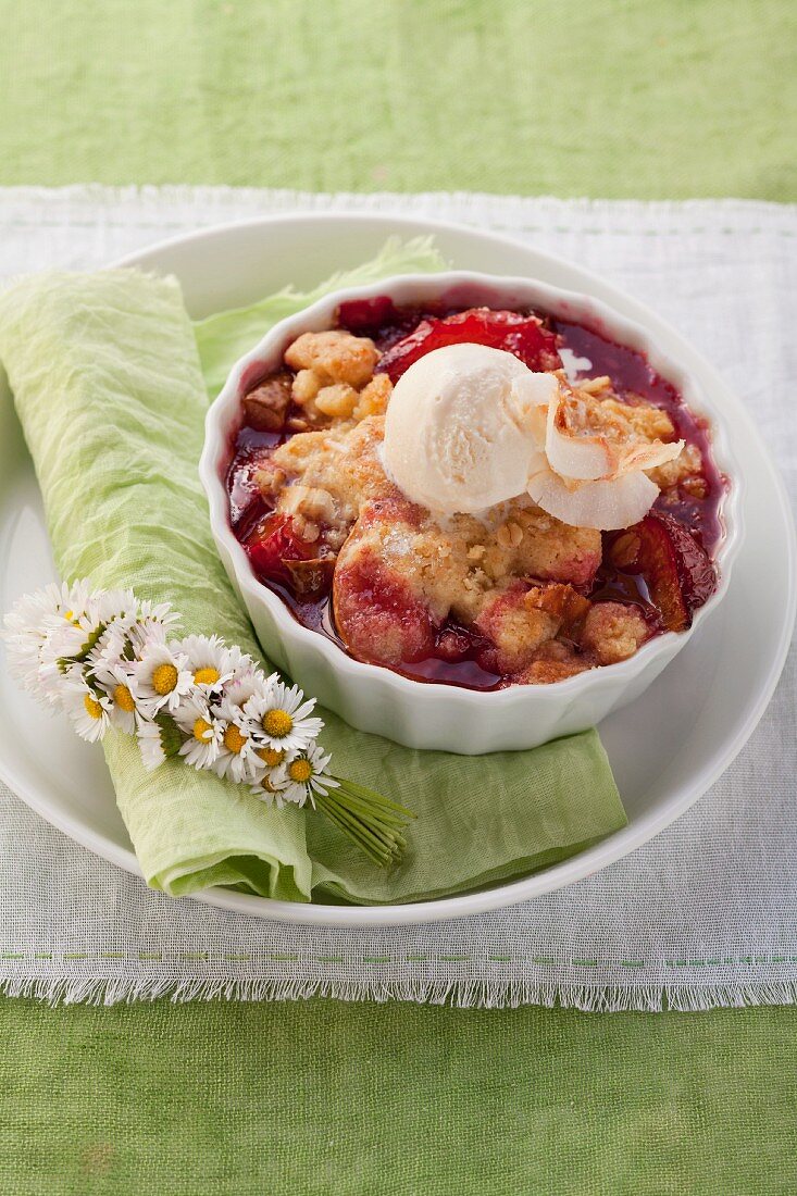 Plum and pear crumble served with vanilla ice cream