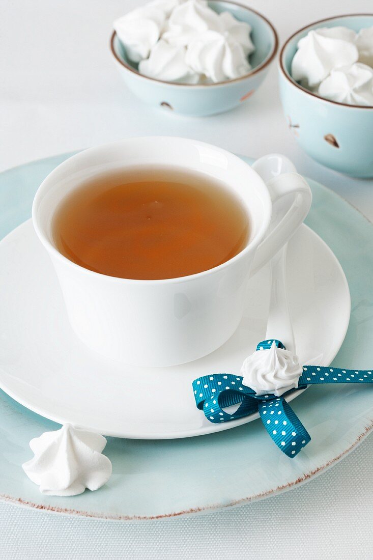Eine Tasse Tee mit Teelöffel und Sahnetupfen-Magneten