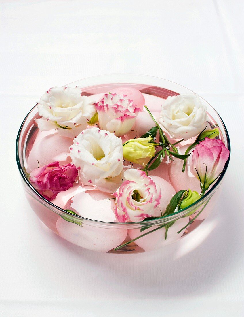 Boiled eggs and lisianthus flowers in a glass bowl of water