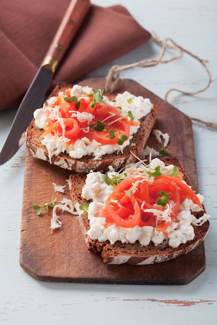 Toasted black bread topped with cottage cheese and smoked salmon