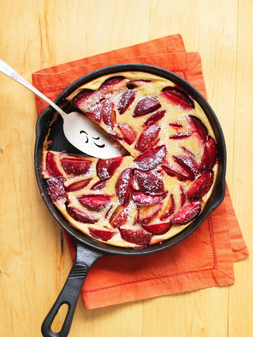 Clafoutis with plums in a pan