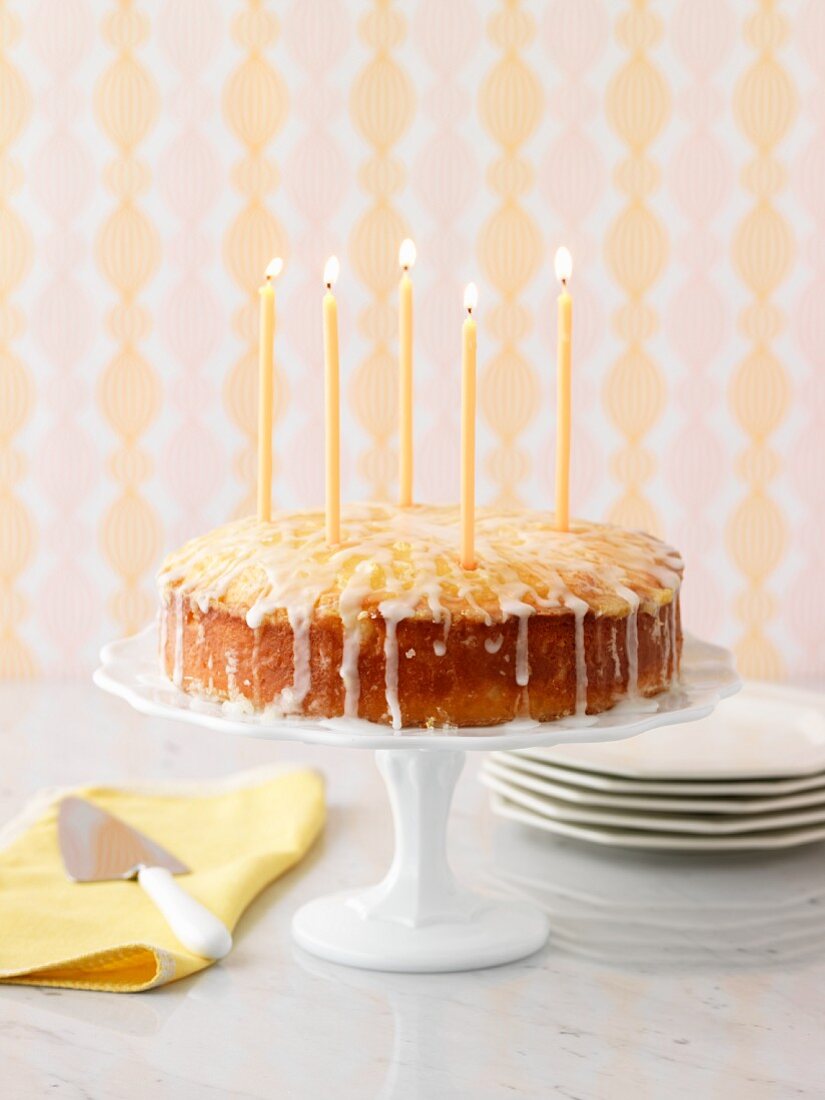 Lemon cake with candles on a cake stand