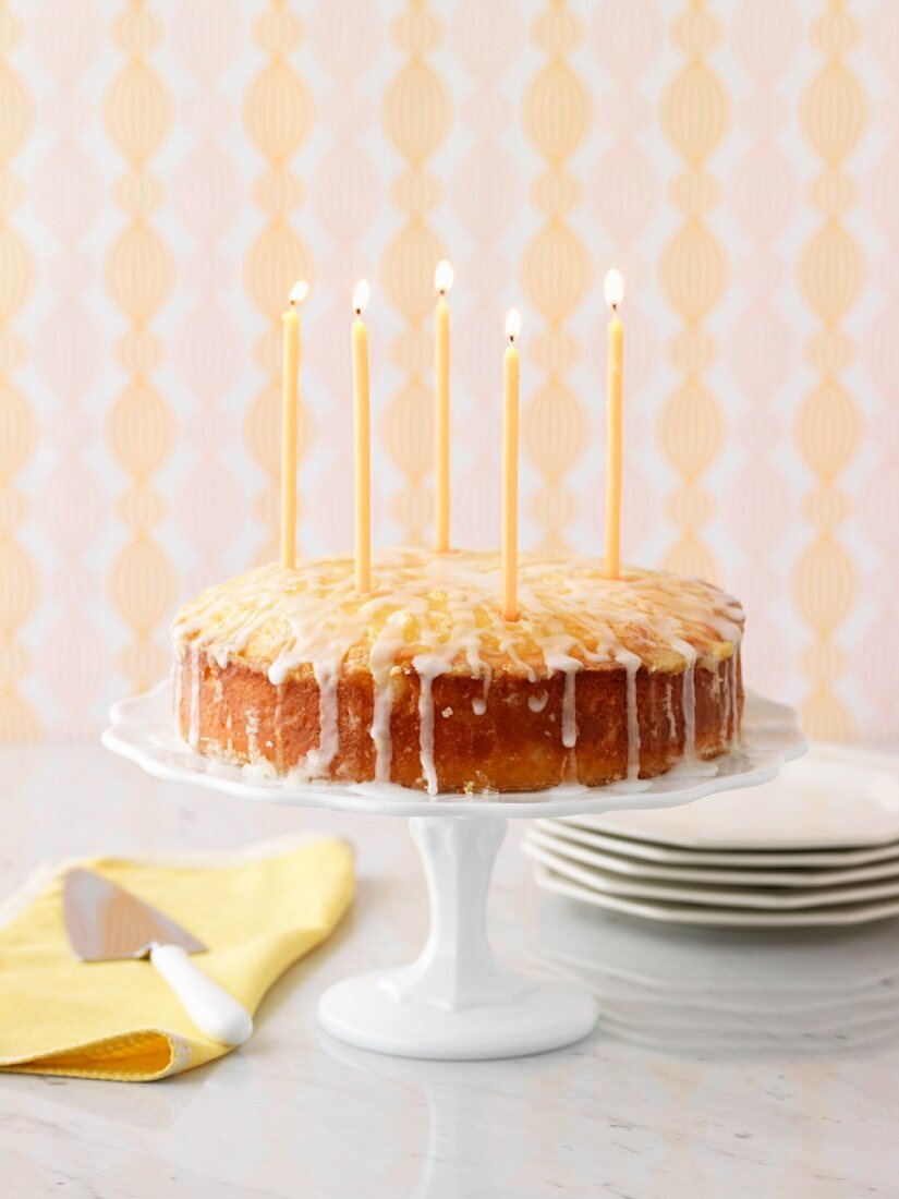 Zitronenkuchen mit Kerzen auf Tortenständer