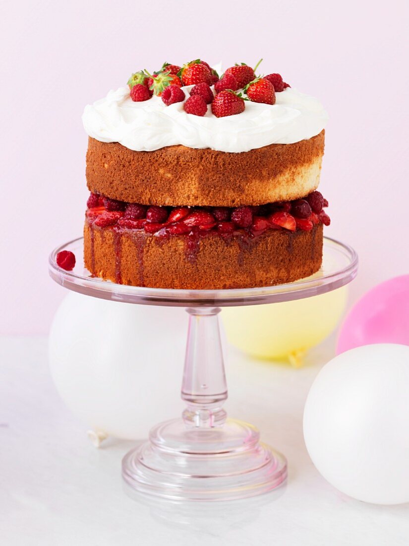 A strawberry and raspberry cake on the cake stand