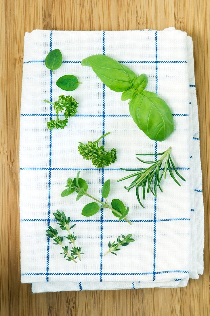 Various fresh herbs on a tea towel