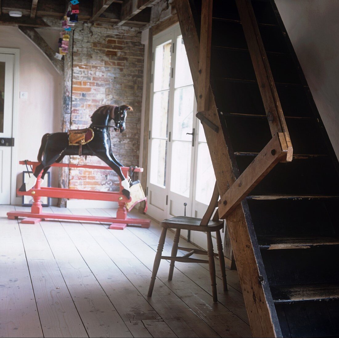A rocking horse and a flight of wooden steps in an anteroom