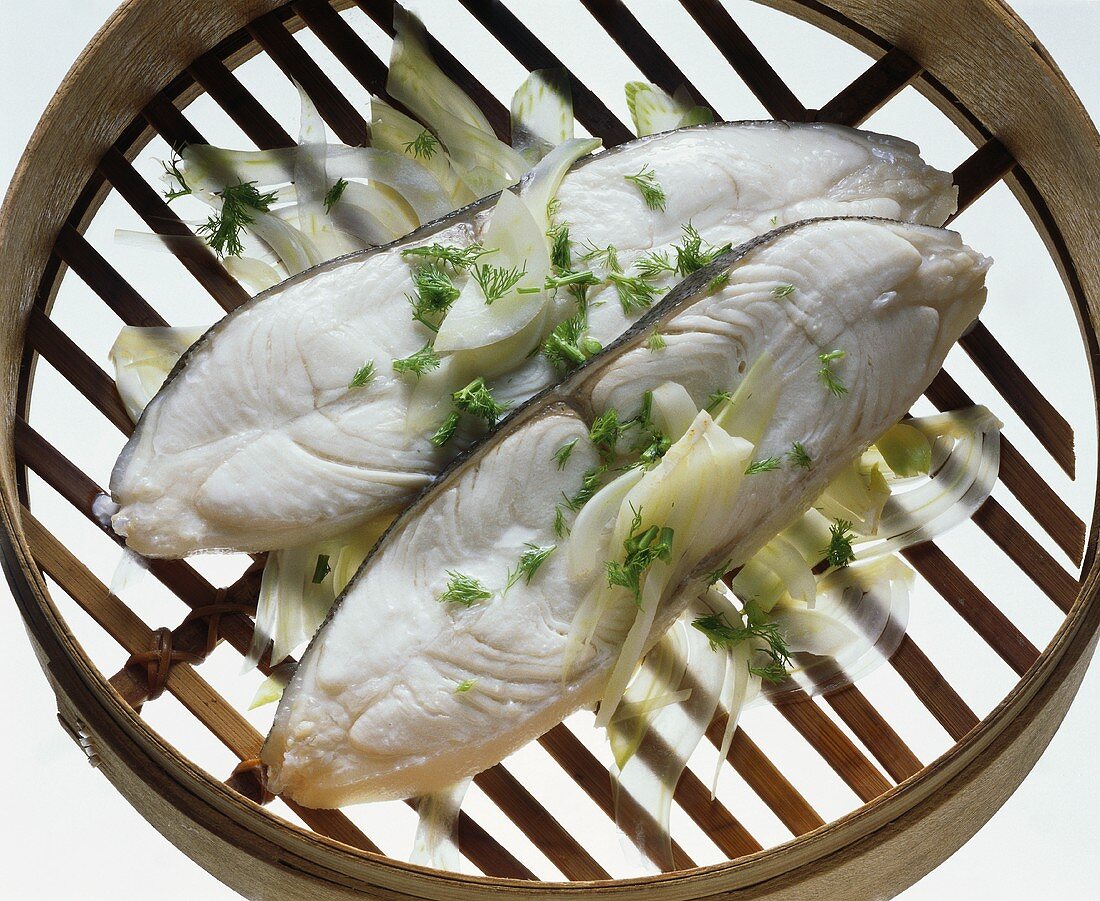 Two halibut cutlets on fennel in steaming basket