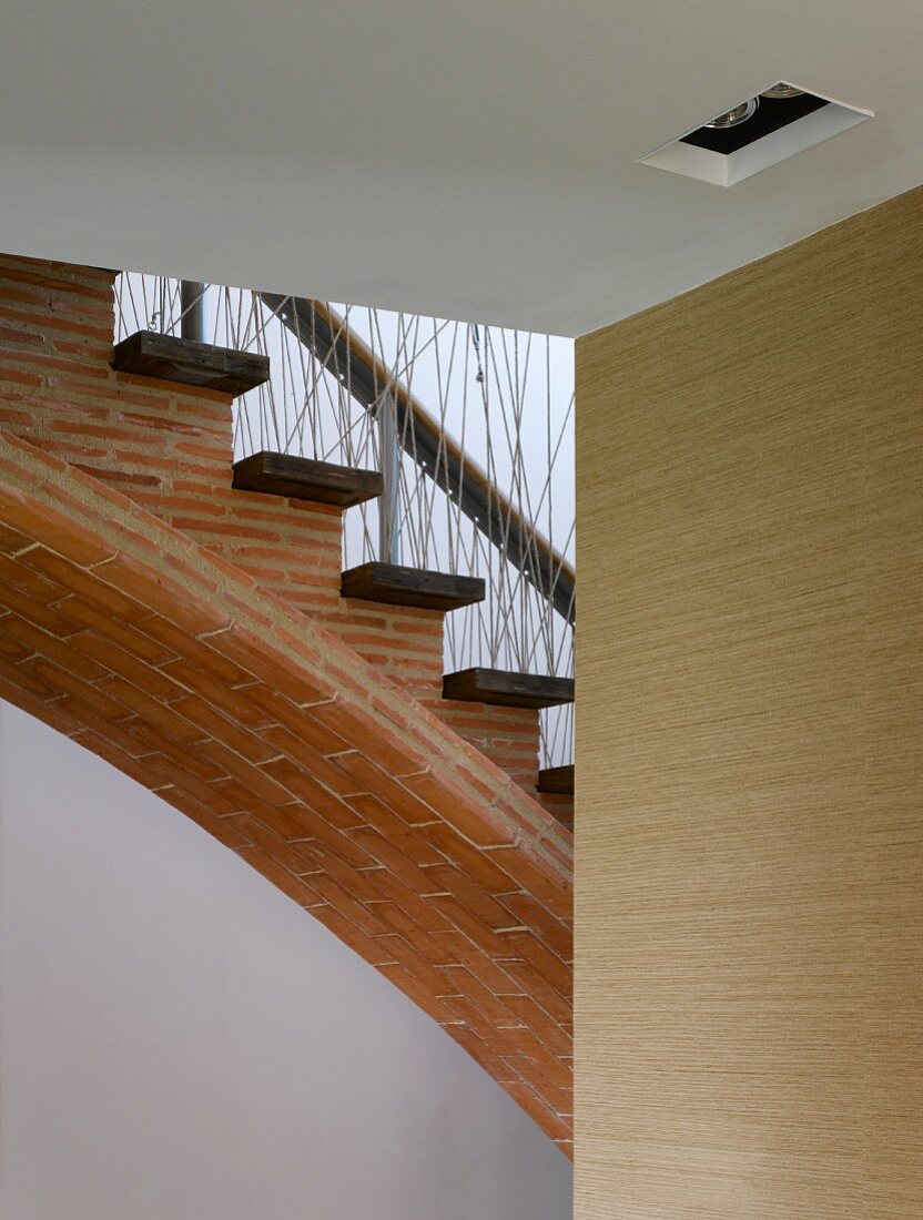 Arched stairs made of narrow bricks with wooden treads and balusters of randomly woven rope