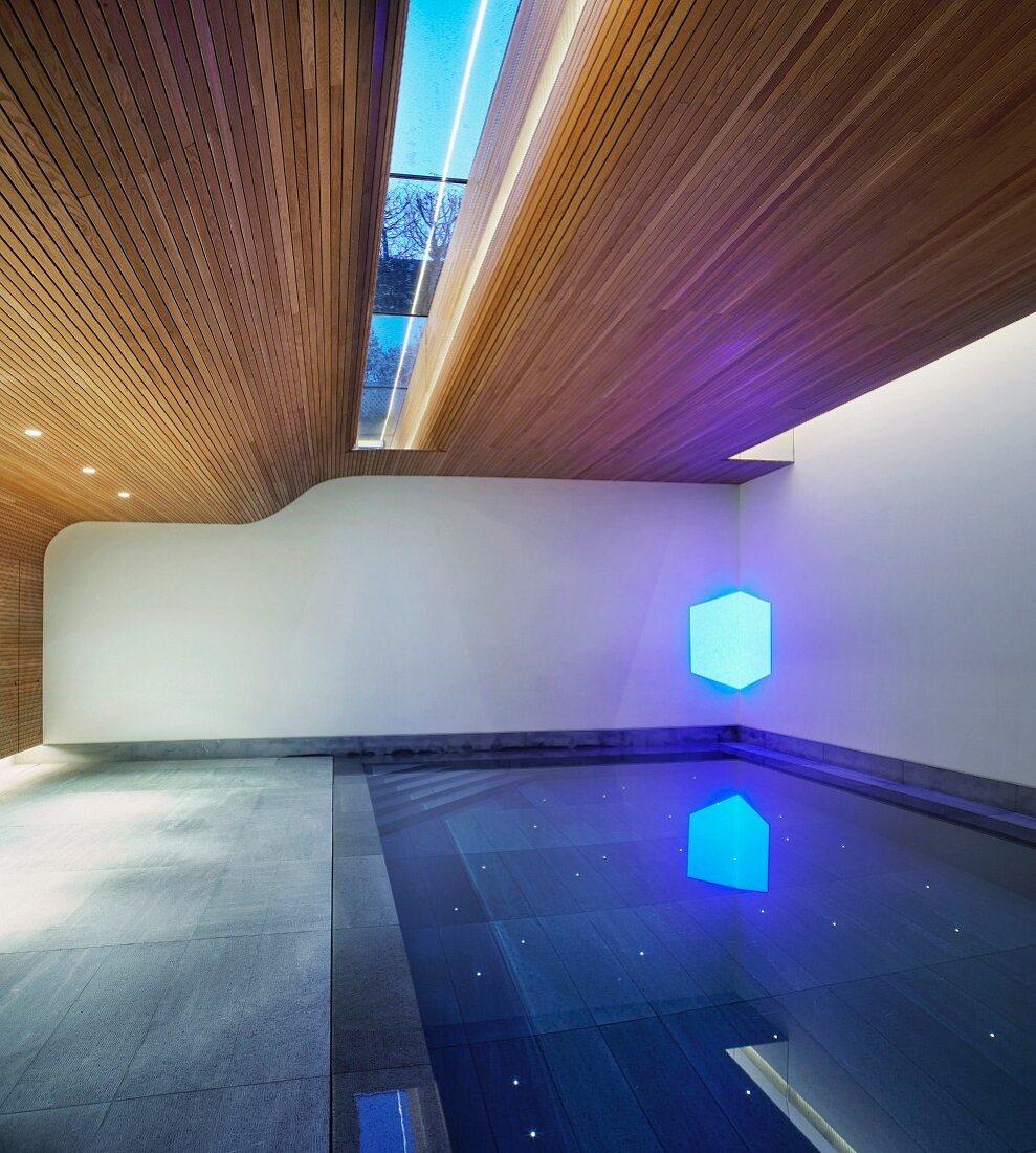 Pool in zeitgenössischem Wohnhaus mit teilweiser Holzverkleidung an Wand und Decke mit Oberlicht