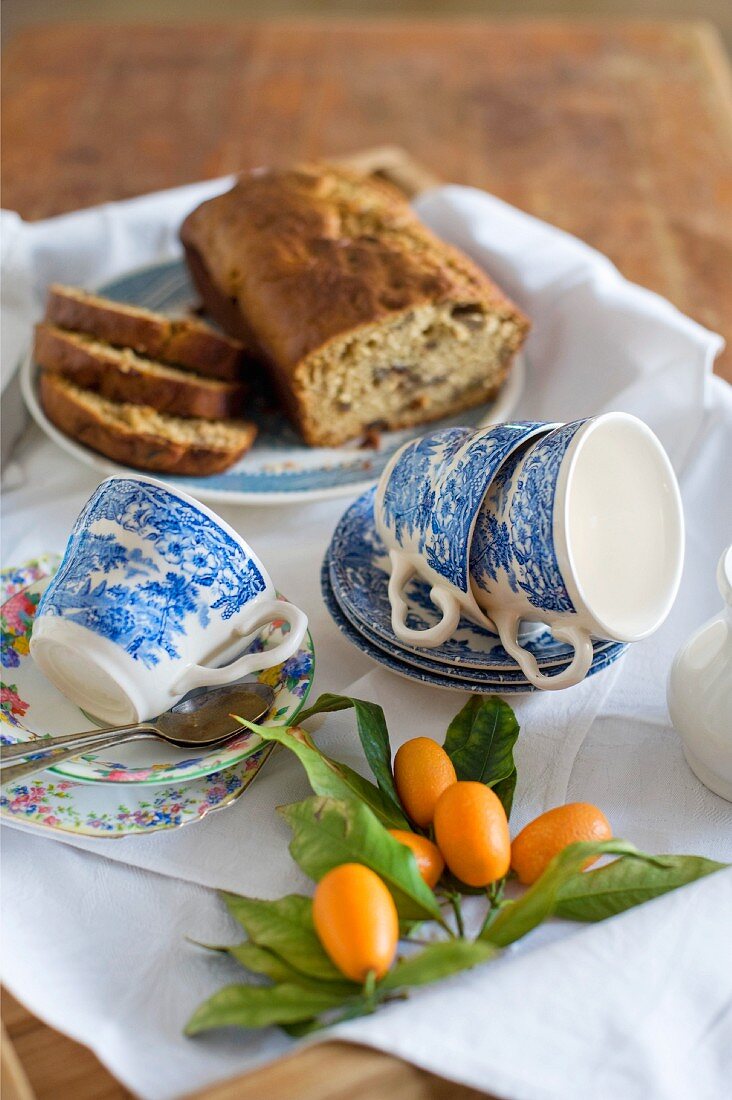Kumquats, blue and white cups and fruit cake