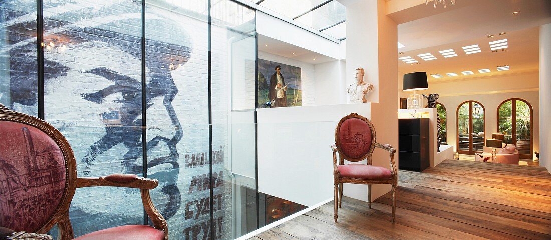 Upholstered, baroque-style chairs in modern, open-plan foyer of a villa