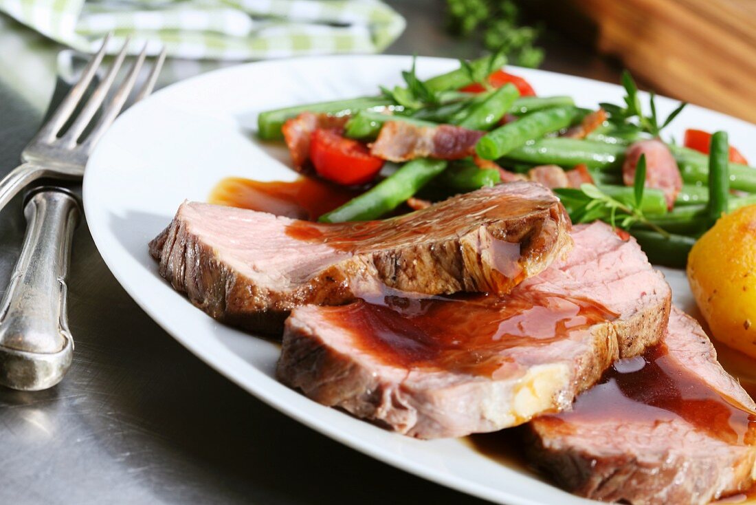 Roast beef with gravy and bacon beans