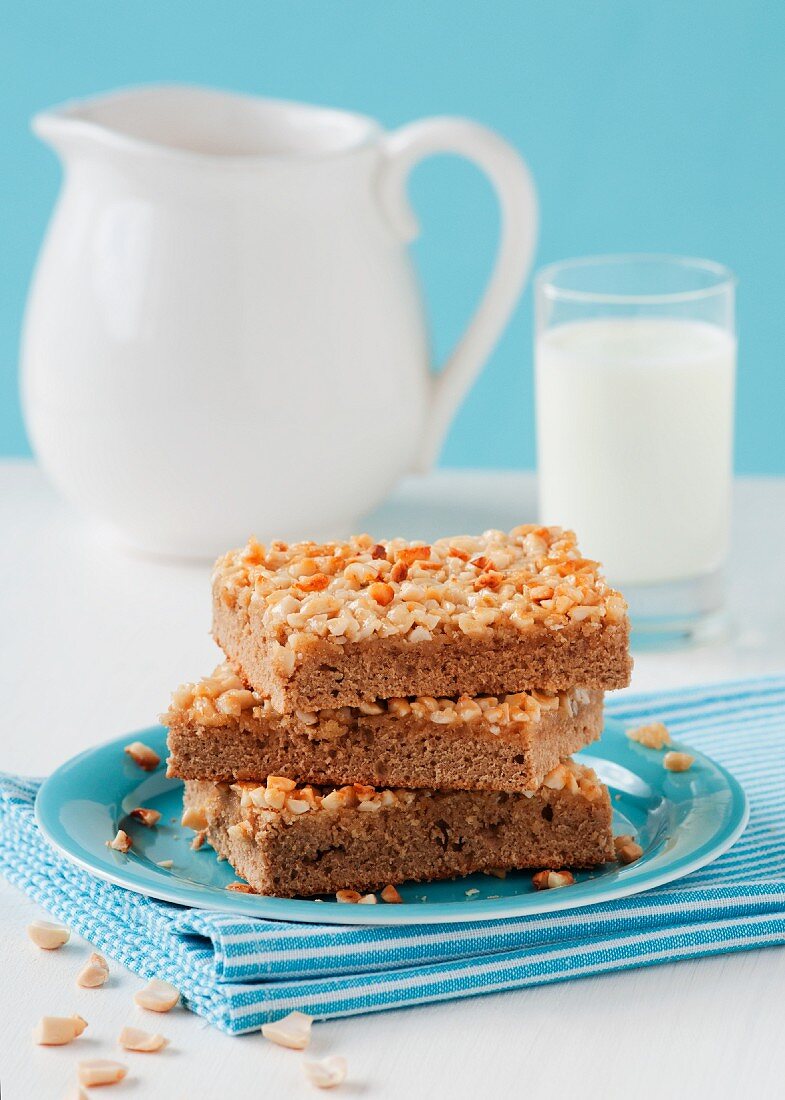Three slices of peanut cake tray bake on a plate