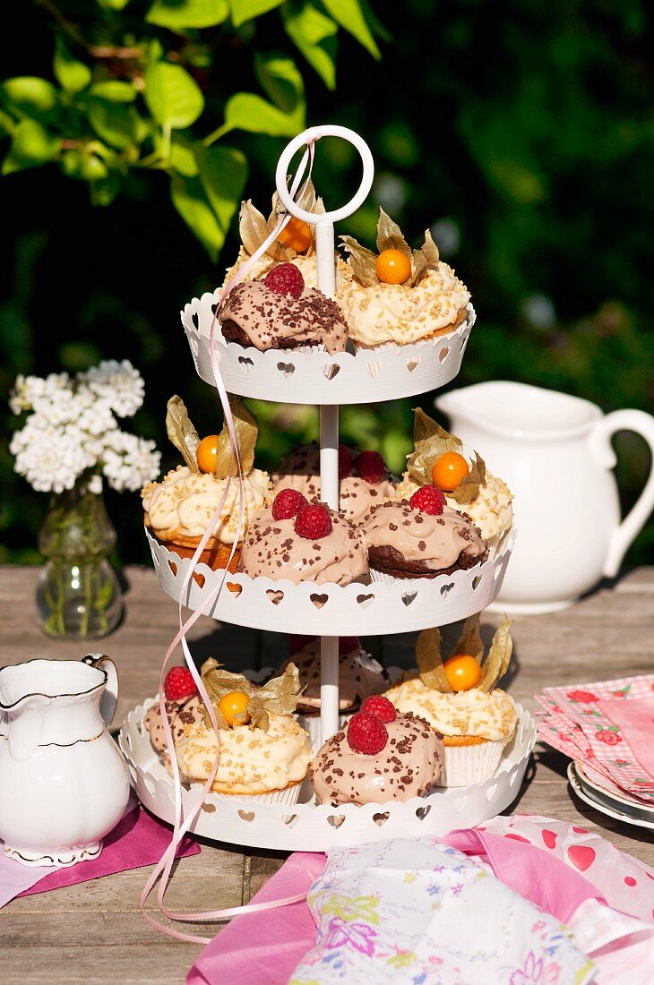Various cupcakes on a cake stand on a garden table