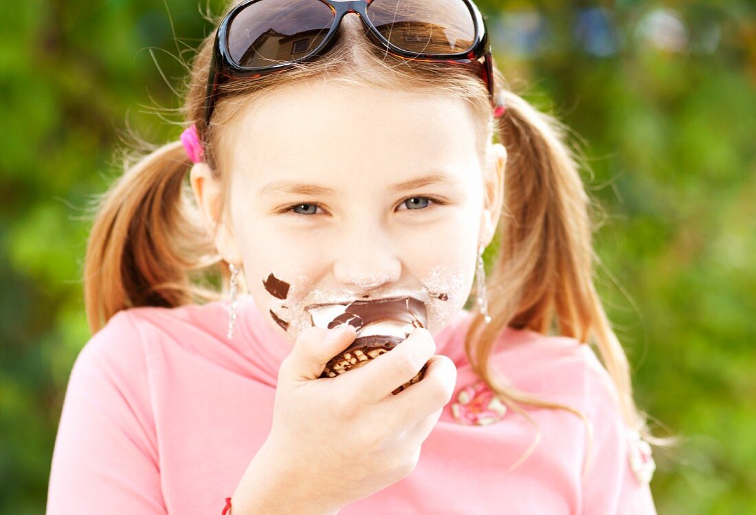 A girl eating a chocolate marshmallow