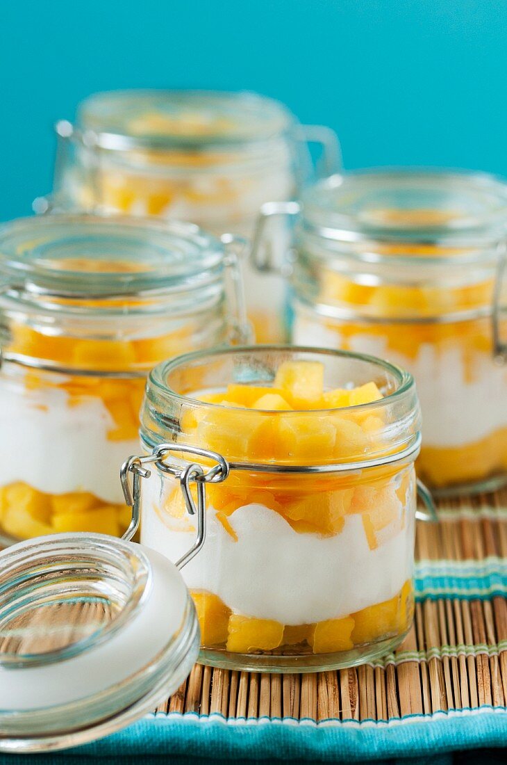 Fresh mango with yogurt in jars