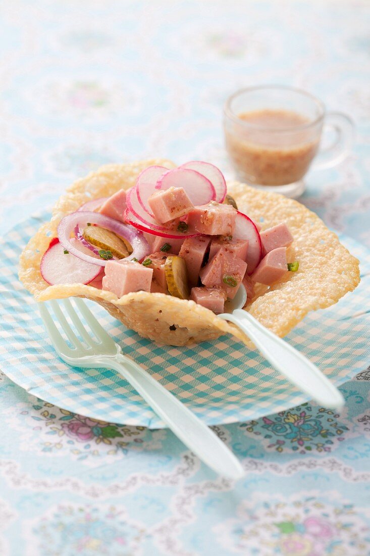 Sausage salad with radishes in a Parmesan bowl
