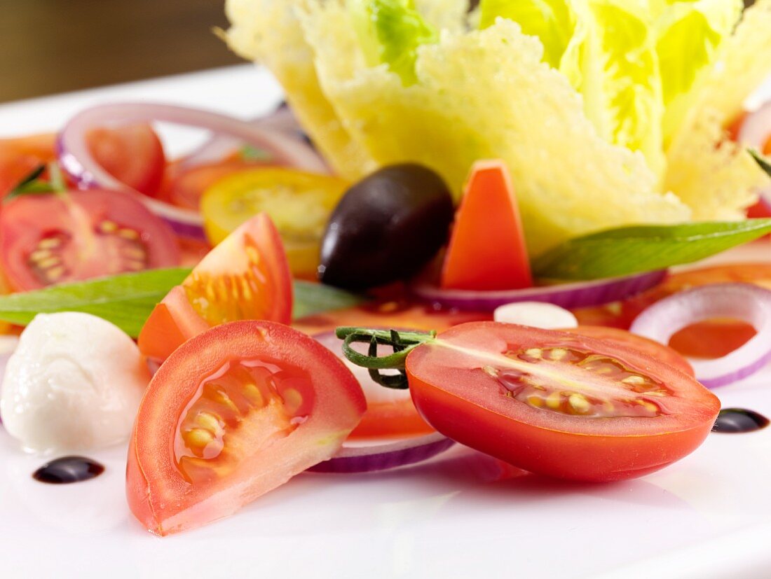 Tomato salad with mozzarella, onions and olives (close-up)