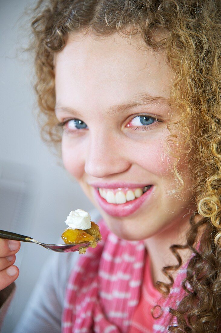 A young girl eating a banana and apple cake