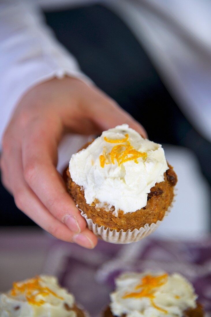 Hand hält Karottenmuffin