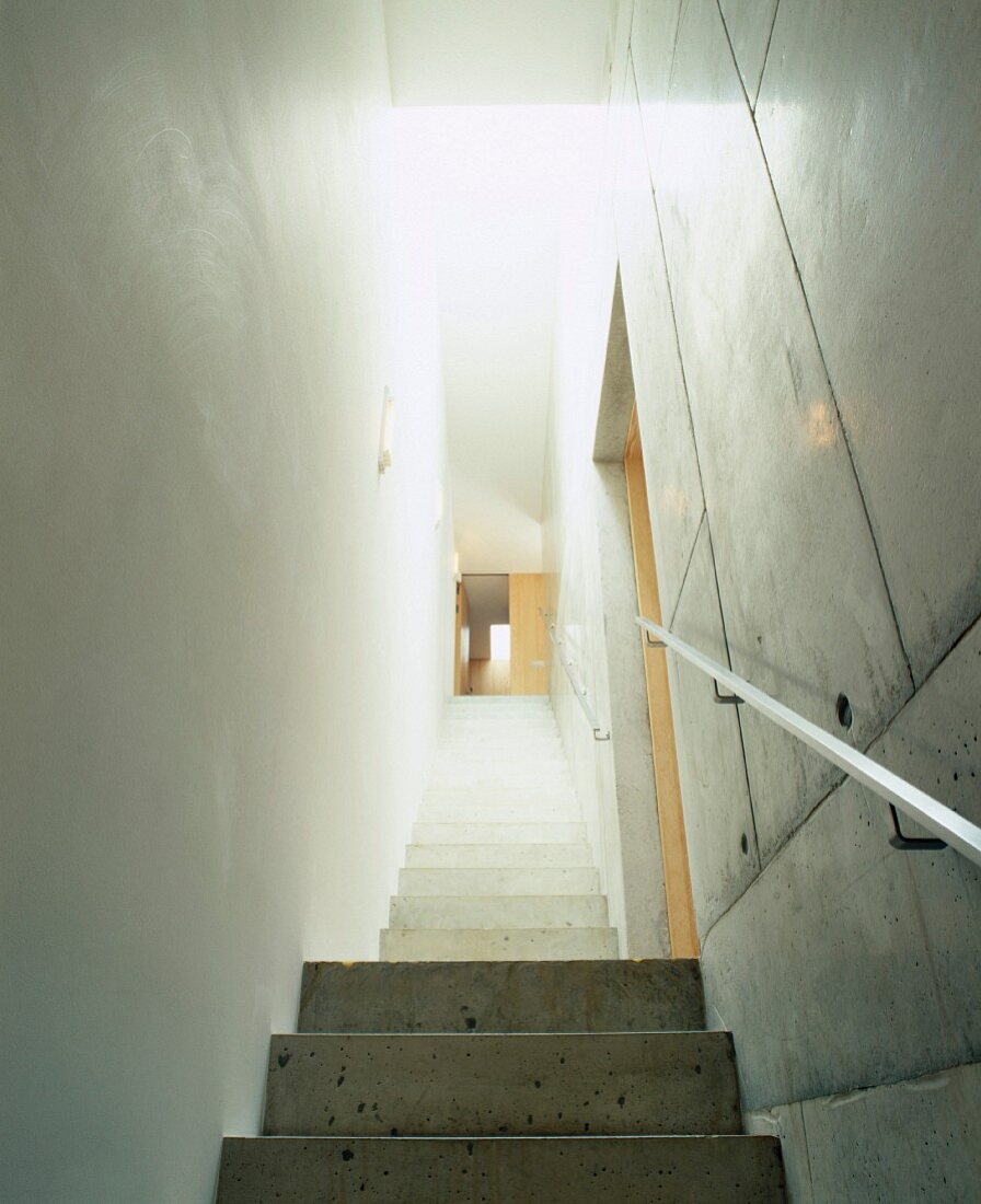 Schmales Treppenhaus mit Stufen und Wand aus Sichtbeton