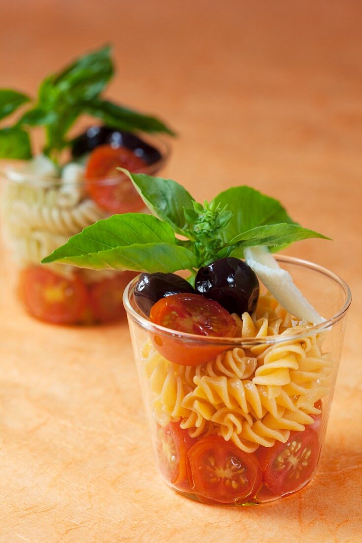 Pasta salad with cocktail tomatoes, olives and basil