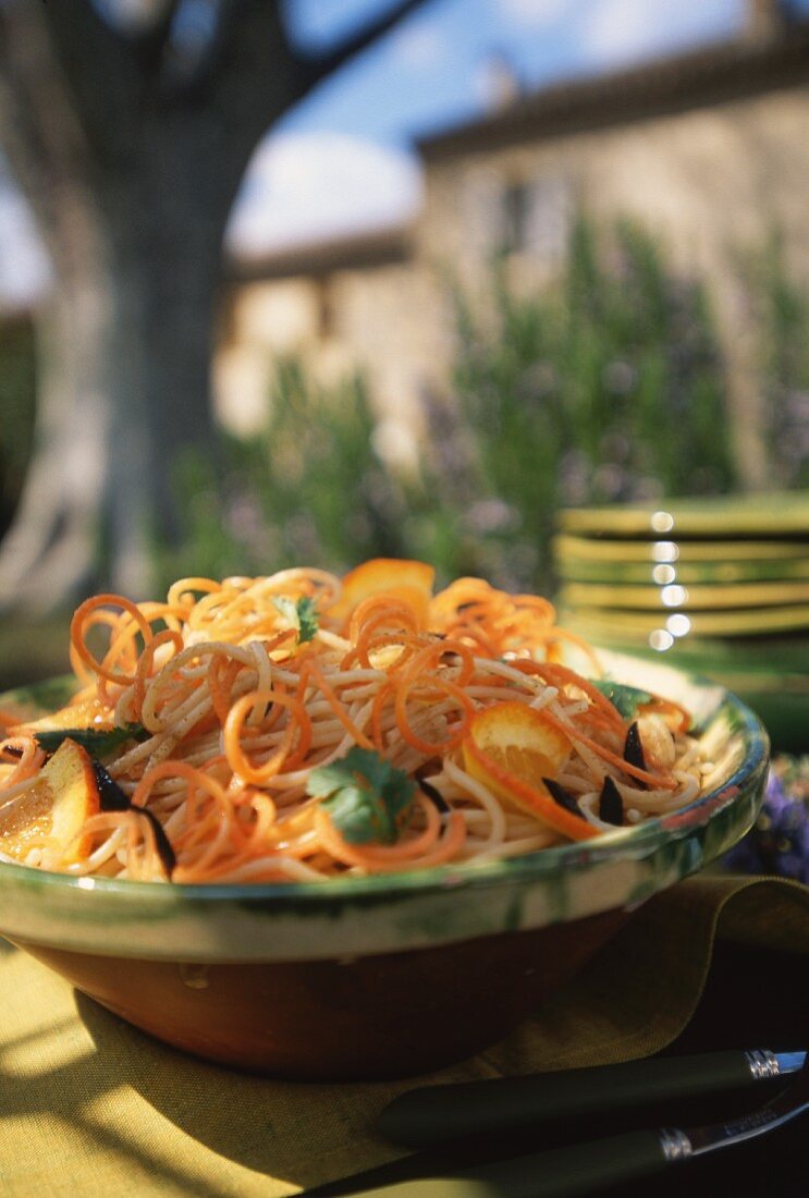 Spaghettoni mit Karotten & Orangen auf Tisch im Freien