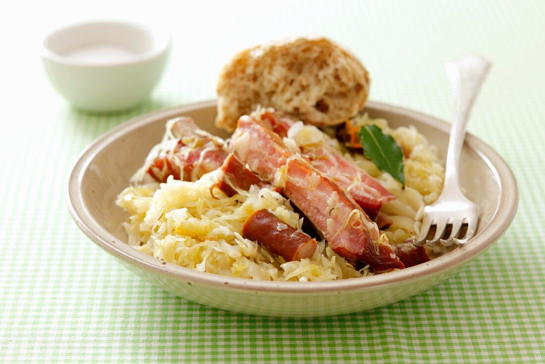 A meat platter with sauerkraut and bread