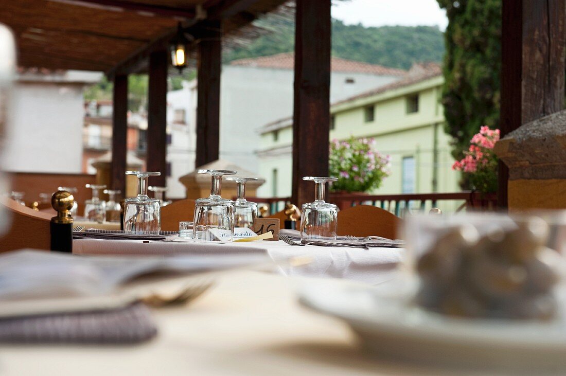 Gedeckte Tische auf der Terrasse eines Restaurants in Sardinien