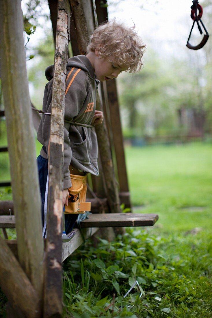 A blond boy working in a garden