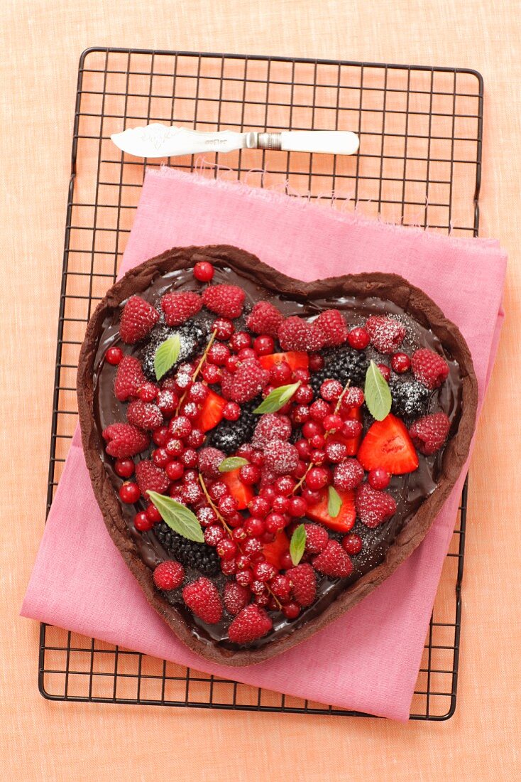 A heart-shaped chocolate cake decorated with berries