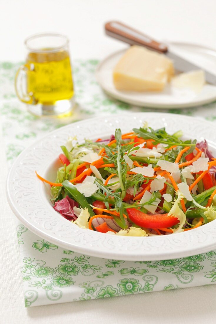 A mixed leaf salad with peppers, red onions and Parmesan cheese