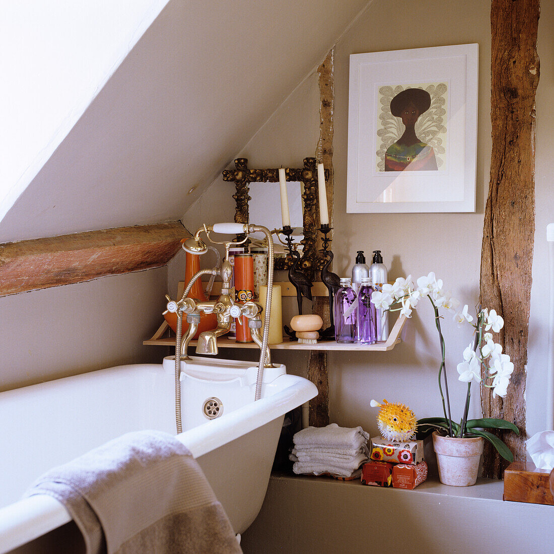 Freestanding bathtub, orchid and shelf in the bathroom with sloping roof